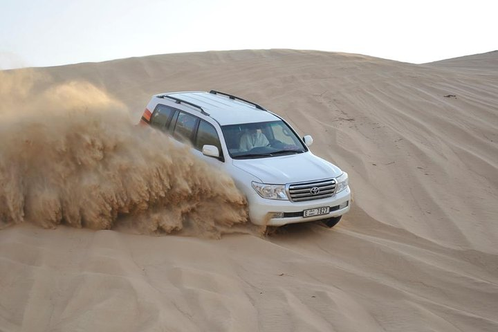 Experience the excitement of dune bashing through golden sands with a 4x4 adventure showcasing the stunning desert landscape perfect for adrenaline seekers and nature lovers alike.